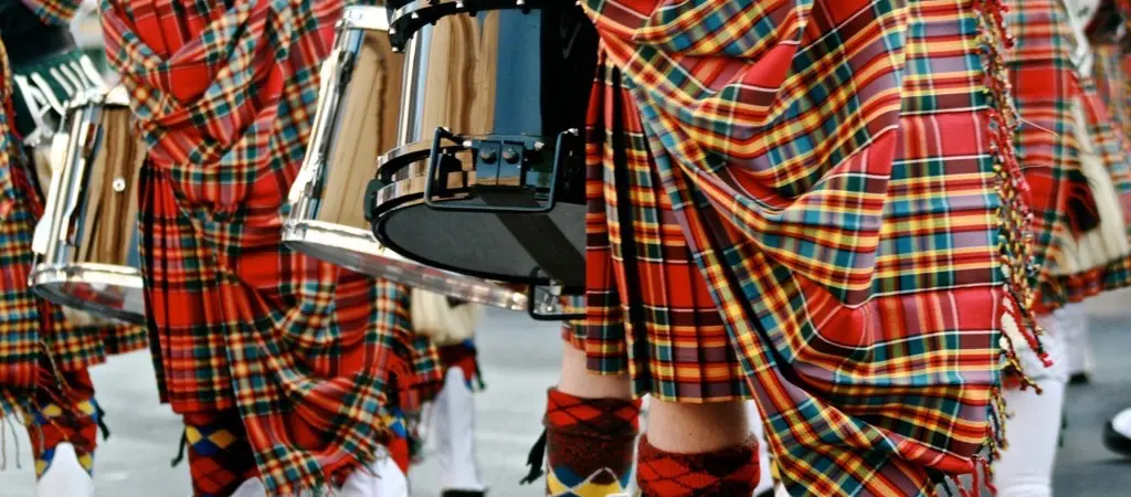 Pipe band marching in tartan uniforms